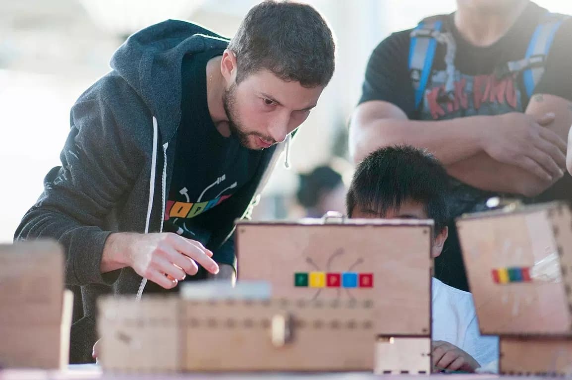 Mark helping a child build a Piper computer kit
